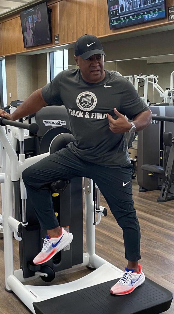 Coach Kyle Meadows in USA Track & Field gear on a Technogym performance machine